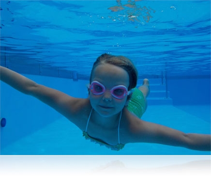 Underwater photo of a girl in a pool looking at the camera