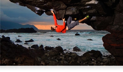 Photo of a rock climber upside down on a cliff over water highlighting the AW120's AF