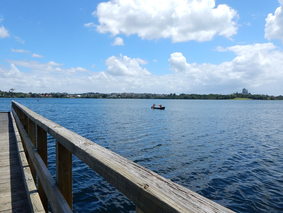 Zoom slider - ultra wide view of a dock and lake with a small boat in the center