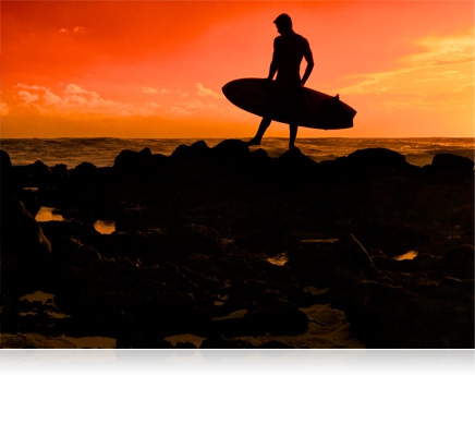 Silhouette photo of a man with a surfboard standing on the jetties