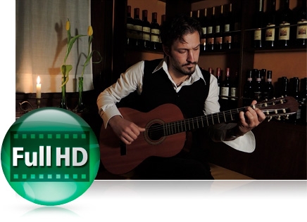photo of a man playing a guitar in low light in a bar